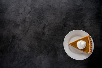 pumpkin pie slice on black background