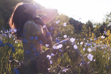 Redhead Woman in Field of Flax Flowers at Sunset