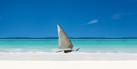 Een exotische zeilboot zit op wit zand in de tropen