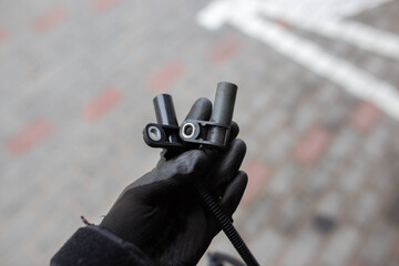 electromagnetic crankshaft position sensor of a car engine in the hands of an auto mechanic.