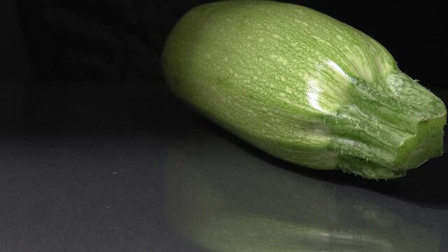 Organic zucchini close-up. Black background. Fresh vegetables.