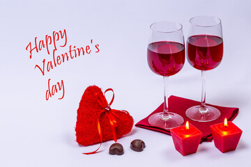 Red wine, chocolate and candles on white background.