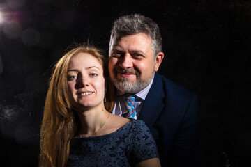 Bearded man and young woman, happy couple studio portrait