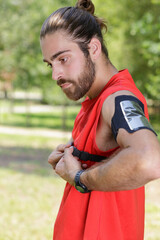 Fototapeta premium male jogger controls heart beats on training outdoor