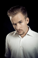 Young man dressed in white shirt studio portrait