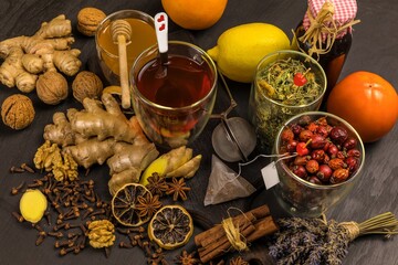 Ginger tea in a cup on black wooden background. Cinnamon and star anise with cloves. Treatment of flu and colds. Herbal medicinal tea.