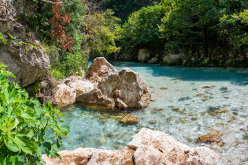 Naklejka na ściany i meble Fresh turquoise water from Acheron springs - Acheron river near the village of Glyki, near Parga, Greece