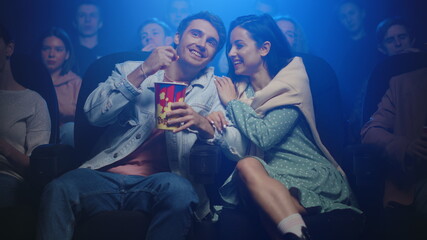 Romantic couple hugging in movie theater. Cheerful people having fun in cinema.