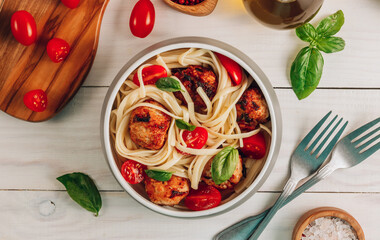 Italian pasta with chicken meatballs, tomatoes and basil.