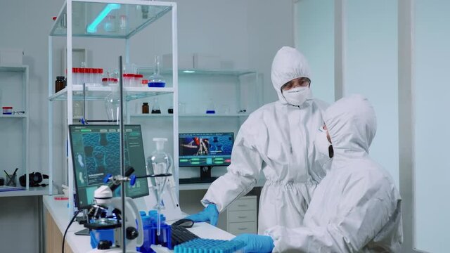 Biotechnology scientist wearing ppe suit researching in equipped laboratory. Team of chemists examining virus evolution using high tech for scientific research of vaccine development against covid19