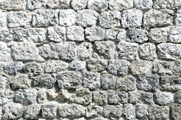 Fragment of a fortified wall made of stones and cemented with cement mortar. Black and white.