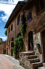 View of an alley with houses of the ancient stone made medieval town, Italy. No people.