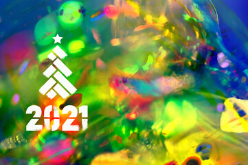 Christmas background-garlands with colorful lights on a decorated Christmas tree, bokeh, Happy New Year 2021 colored symbol and text in trendy flatten style design for seasonal holidays flyers