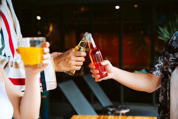 Men toasting wine bottle at bar.
