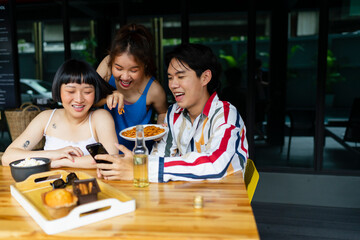 Asian people having fun watching people live stream on smartphone.