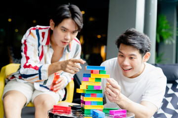 Asian young men having fun playing jenga.