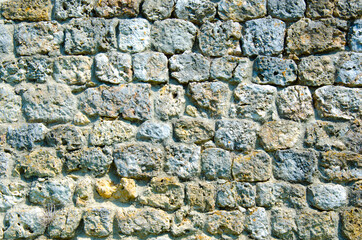 Fragment of a fortified wall made of stones and cemented with cement mortar