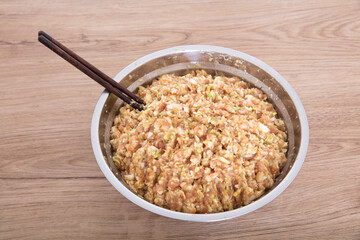The steel pot is filled with prepared pork and green onion dumplings