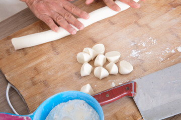The pastry chef gradually rolled the dough on the cutting board to a pile of small dough on the cutting board