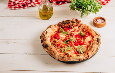 Pizza Margherita on a wooden background. Freshly baked crispy pizza with tomatoes and mozzarella.