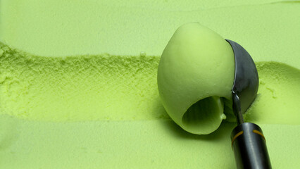 Closeup Scoop lime ice cream out from container with a spoon, Food concept Top view Blank for design..