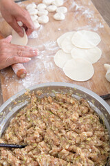 Roll out the dumpling wrappers on a cutting board to prepare dumplings