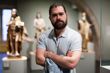 Man visiting sculpture hall in historical museum and looking at exhibits. High quality photo