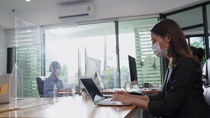Asian businesswoman wearing face mask working on computer in office - Powered by Adobe
