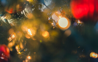 Fototapeta na wymiar Defocused of glow light bulb on Christmas tree. Abstract motion blur colorful glamour bokeh.