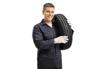 Auto mechanic worker carrying car tire on shoulder and smiling at camera