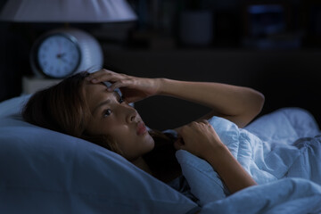 Depressed young woman lying in bed cannot sleep from insomnia