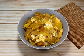 Fried and stirred sliced pumpkin meat with chicken egg on the bowl. Famous traditional vegetarian menu in Asia restaurant. High vitamin and fiber food menu. 