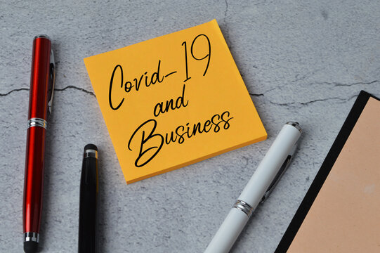 Selective focus of colorful pen, notebook and memo note written with text COVID-19 AND BUSINESS.