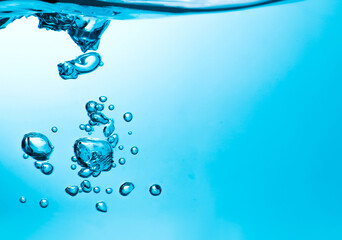 Pouring made a splash of blue waves under the water and Bubbles flowing up on water surface in nature. with copy space