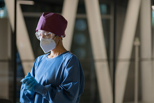 医療用ゴーグルとマスクをつけた手術着姿の女性医師