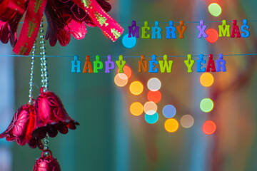 English letters that form the word Merry X Mas and Happy New Year There are decorations and bokeh background.
