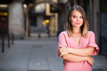 Fototapeta premium Portrait of handsome smiling woman walking on European city street