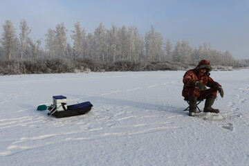 fisherman catches fish from under the ice