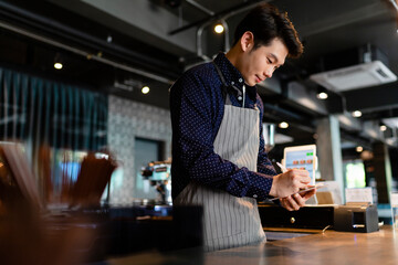Barista man taking order from customer in cafe.