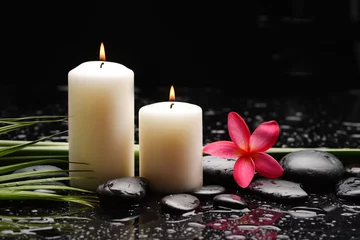 Foto auf Acrylglas spa still life of with red frangipani and two candle with zen black stones ,green palm wet background © Mee Ting