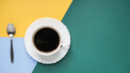 Top view of coffee cup on yellow and green and blue  background
