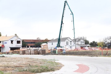 Construction site with concrete, soil, dirt around and crane working