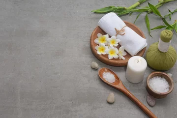  Concept for spa salon, with frangipani, White bath towel and  herbal ball, in wooden bowl candle,stone,salt inspoon and bamboo  on gray background, Copy space  © Mee Ting