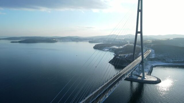 View from above. Closed Russian bridge due to icing of cables in Vladivostok. Panoramic shot of the road blocked due to an ice storm on the bridge against the background of the Russky Island 