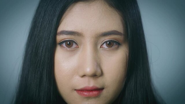 A close up portrait on a beautiful Asian woman face looking at the camera, biometric retina recognition algorithm technology scanning concept