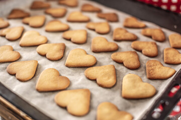 A baking sheet with delicious homemade cookies in the shape of a heart. Concept of fresh homemade cakes or a surprise for Valentine's Day