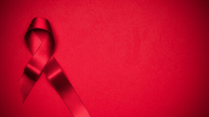 Breast cancer woman. Red ribbon symbol in hiv world day on dark red background. Awareness aids and cancer. Healthcare and medical concept.