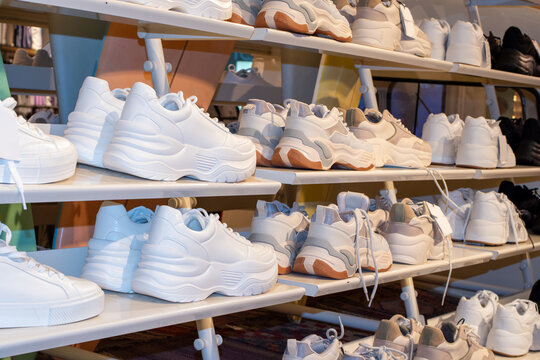 Side view of the shelves of a shoe store with many sales of sneakers. Close up image of some sneakers in a store