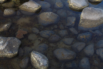 Transparent shallow water with stones on the sand and seaweed around stones. Long exposure.
