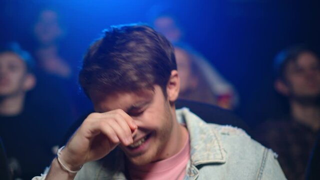 Cheerful man looking comedy in movie theater. Happy guy laughing in cinema.